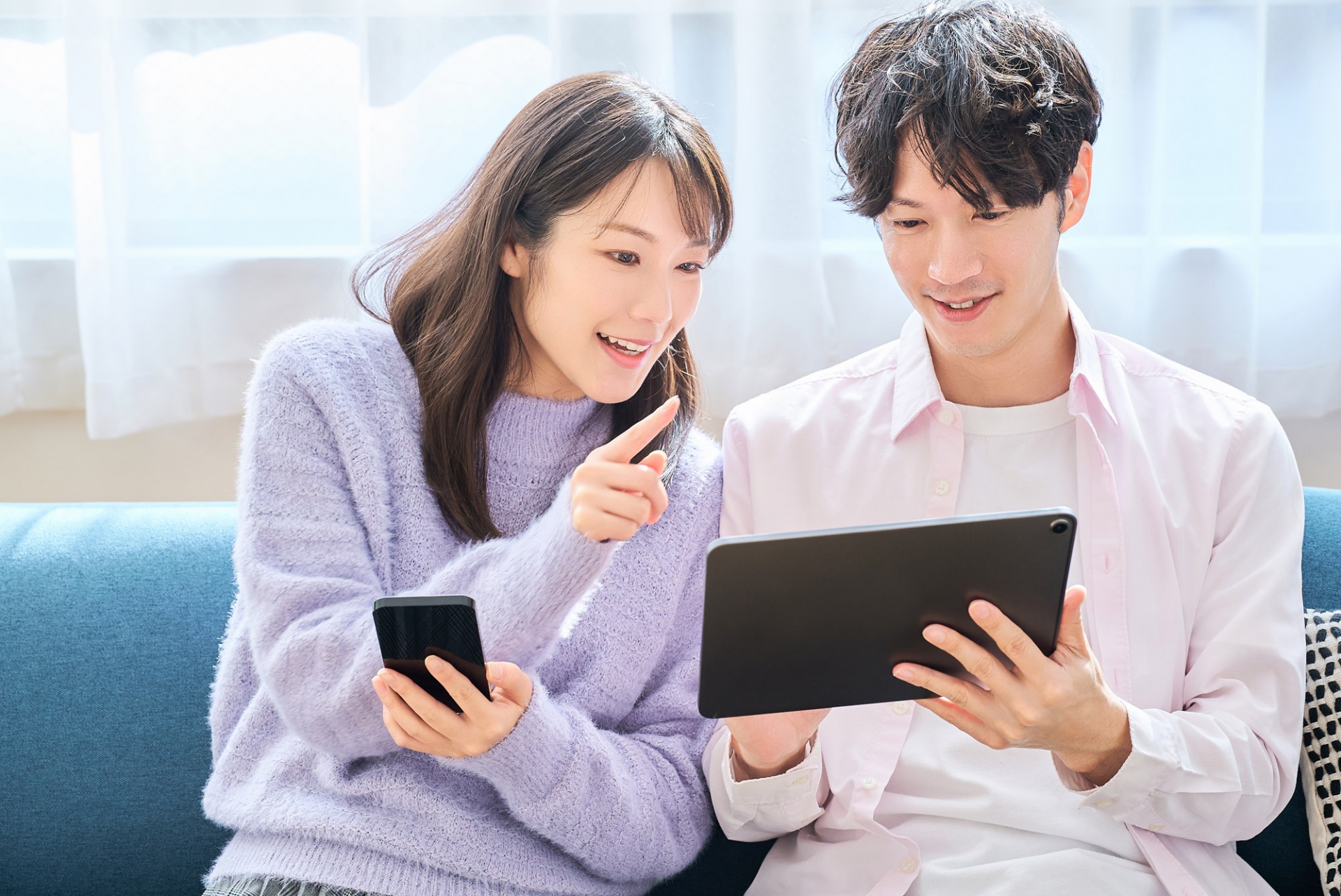 タブレットを見るカップル