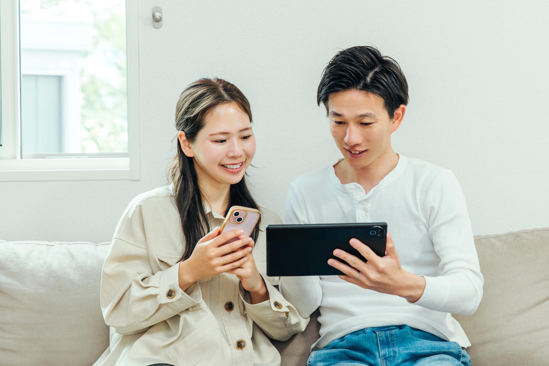 スマートフォンとタブレットを確認する男女