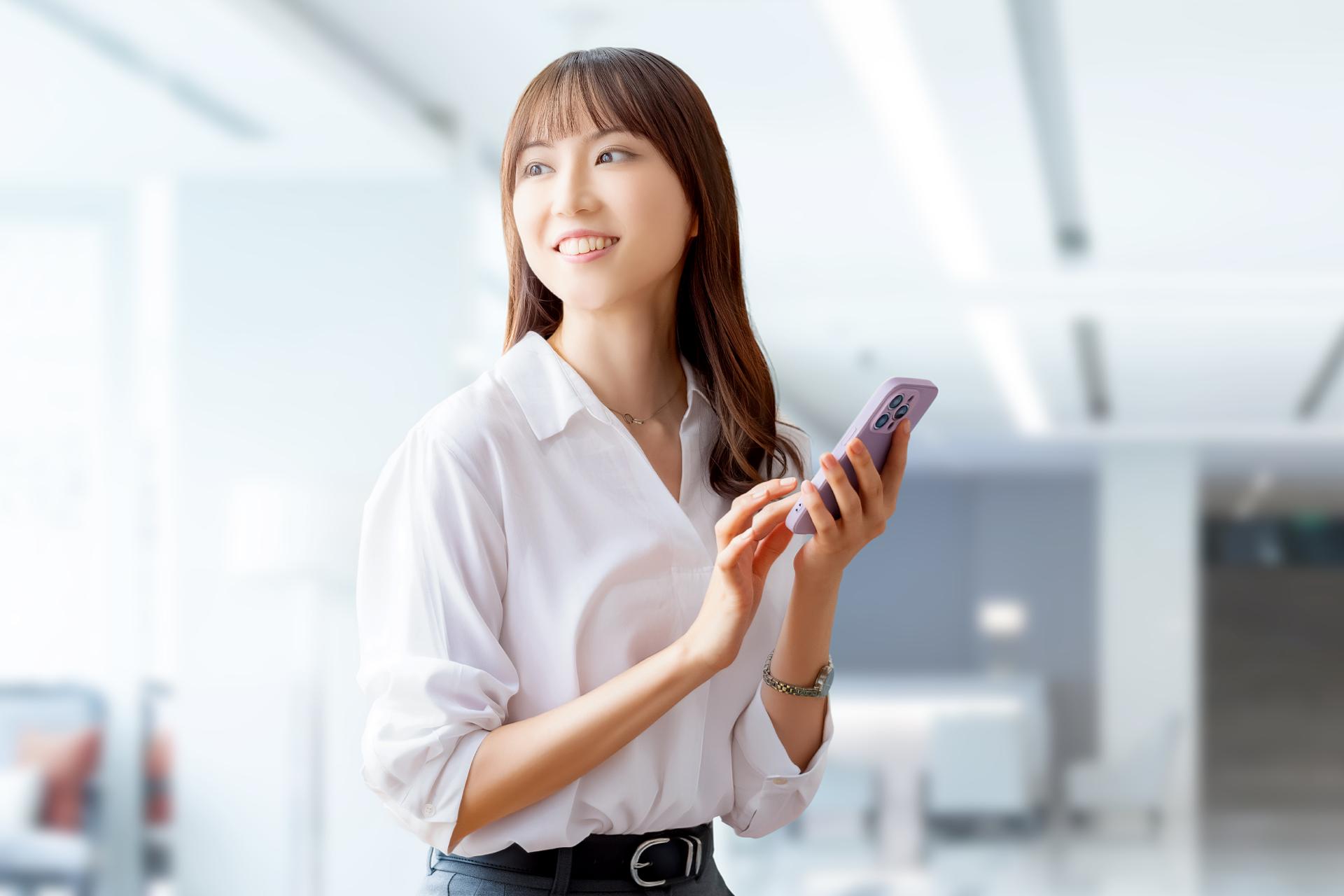スマートフォンを手に考える女性