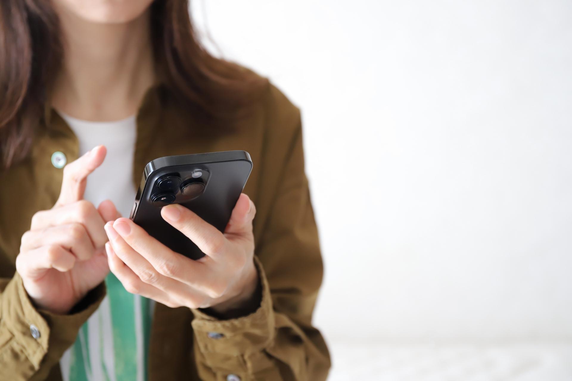 スマートフォンを指で操作する女性
