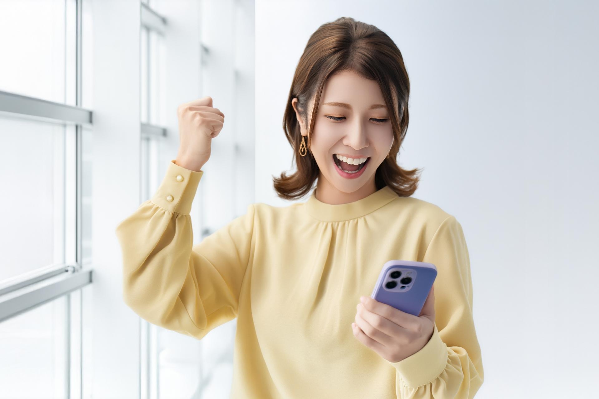 スマートフォンを見て喜ぶ女性