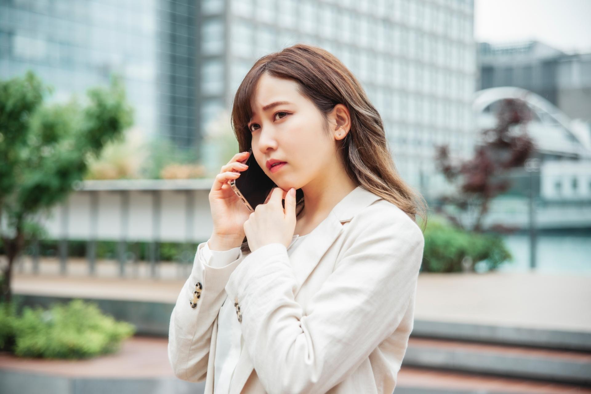 屋外でスマートフォンによる通話をする女性
