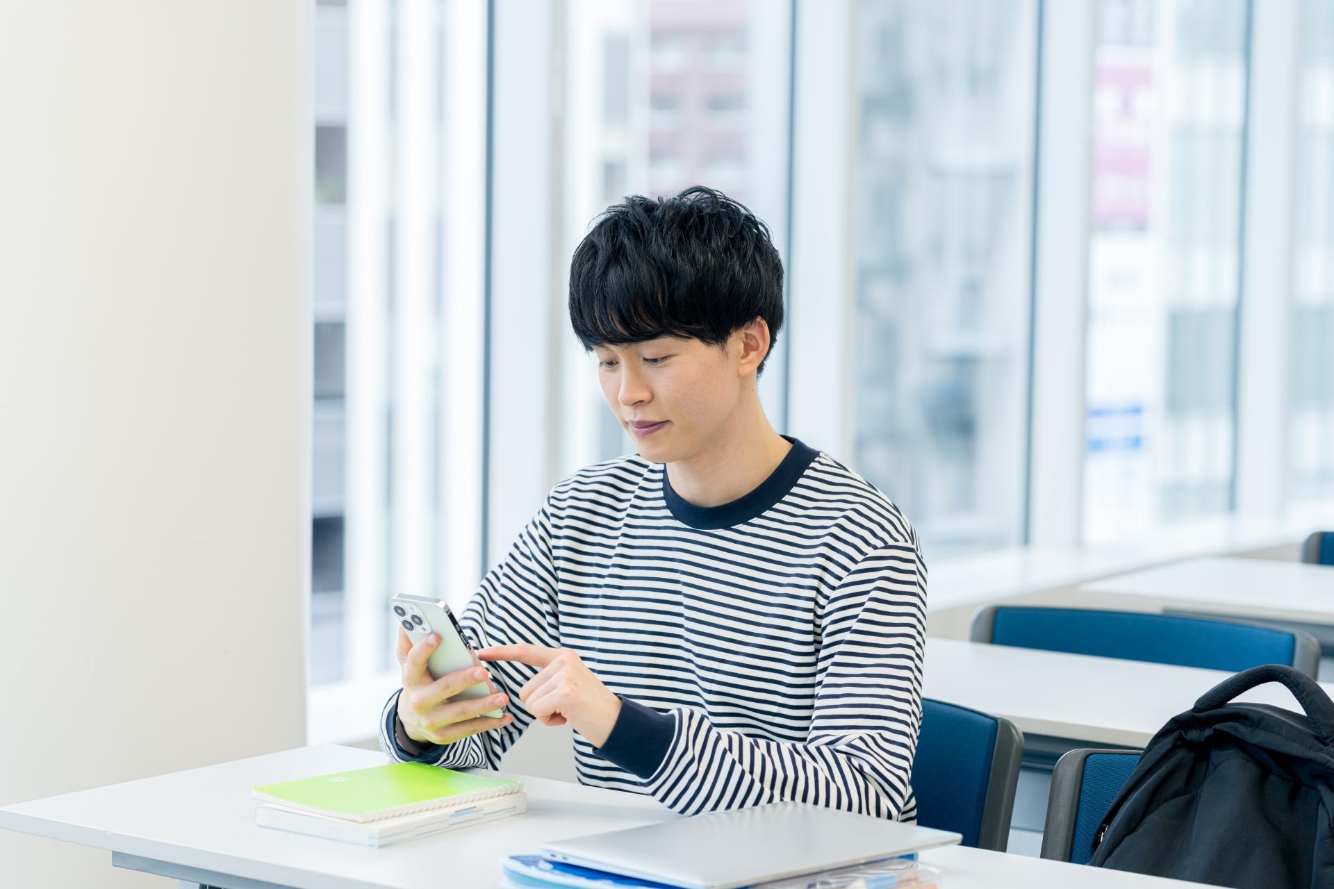 机でスマートフォンを使う男性