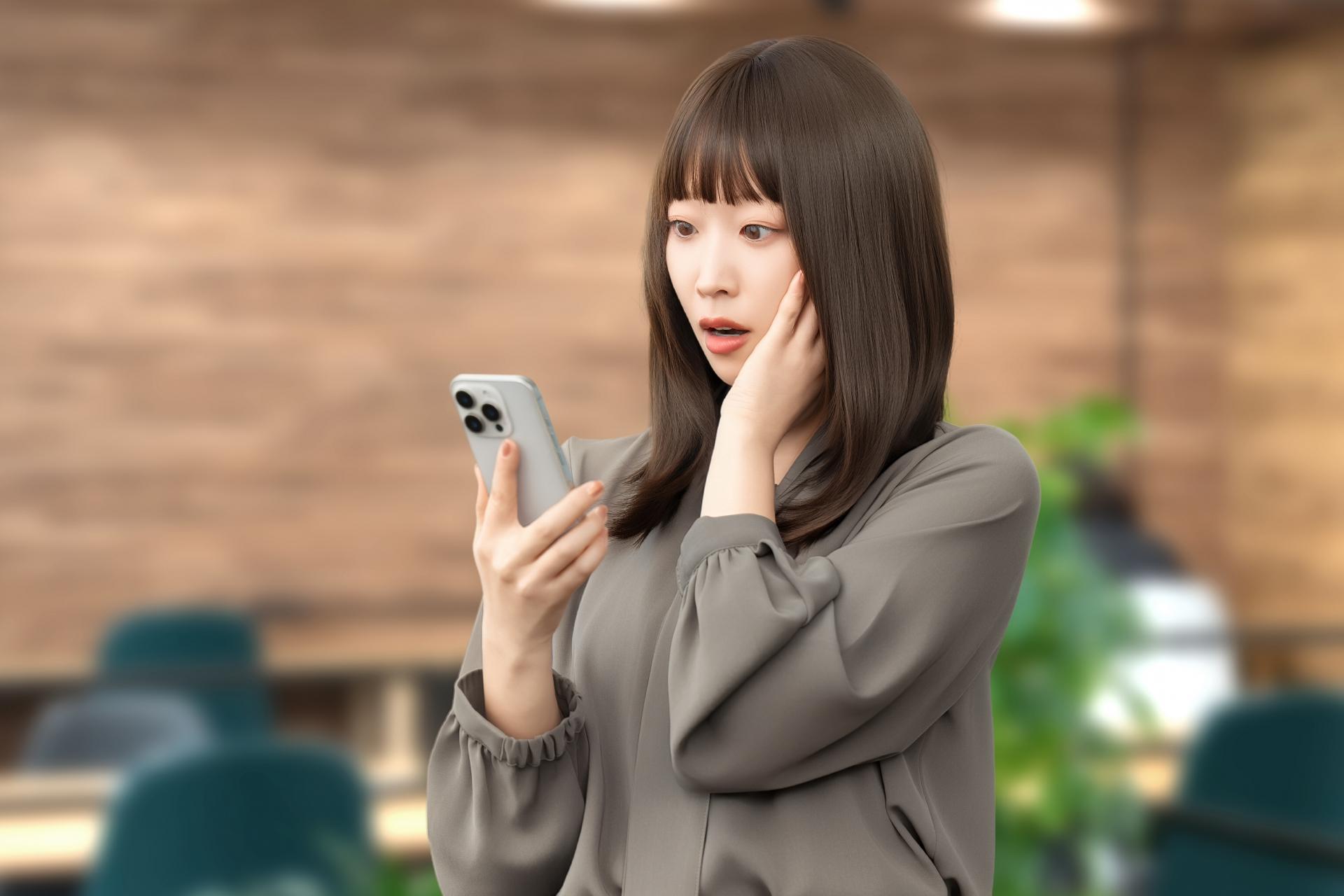 スマートフォンを見て驚く女性
