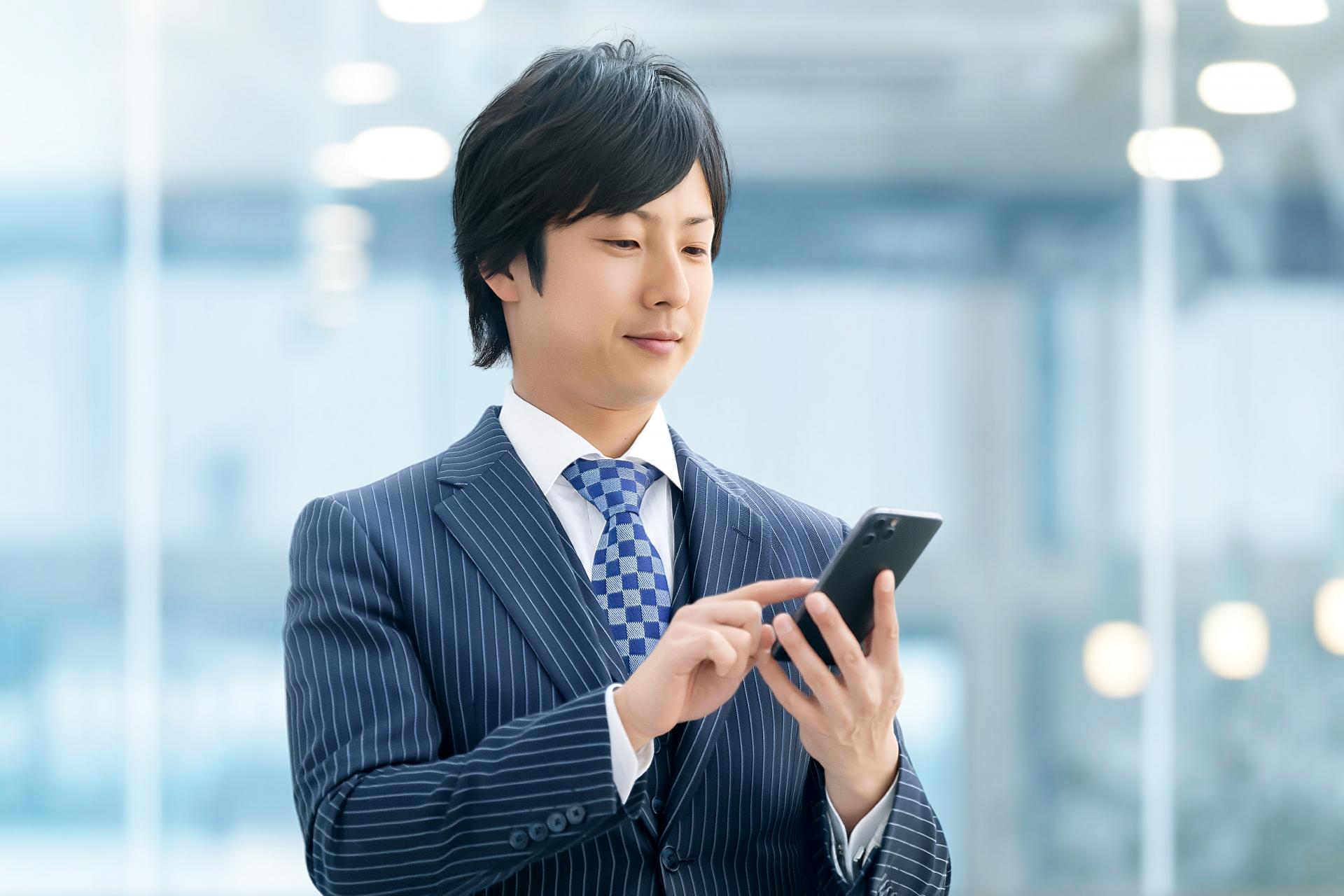 スマートフォンを操作するスーツ姿の男性