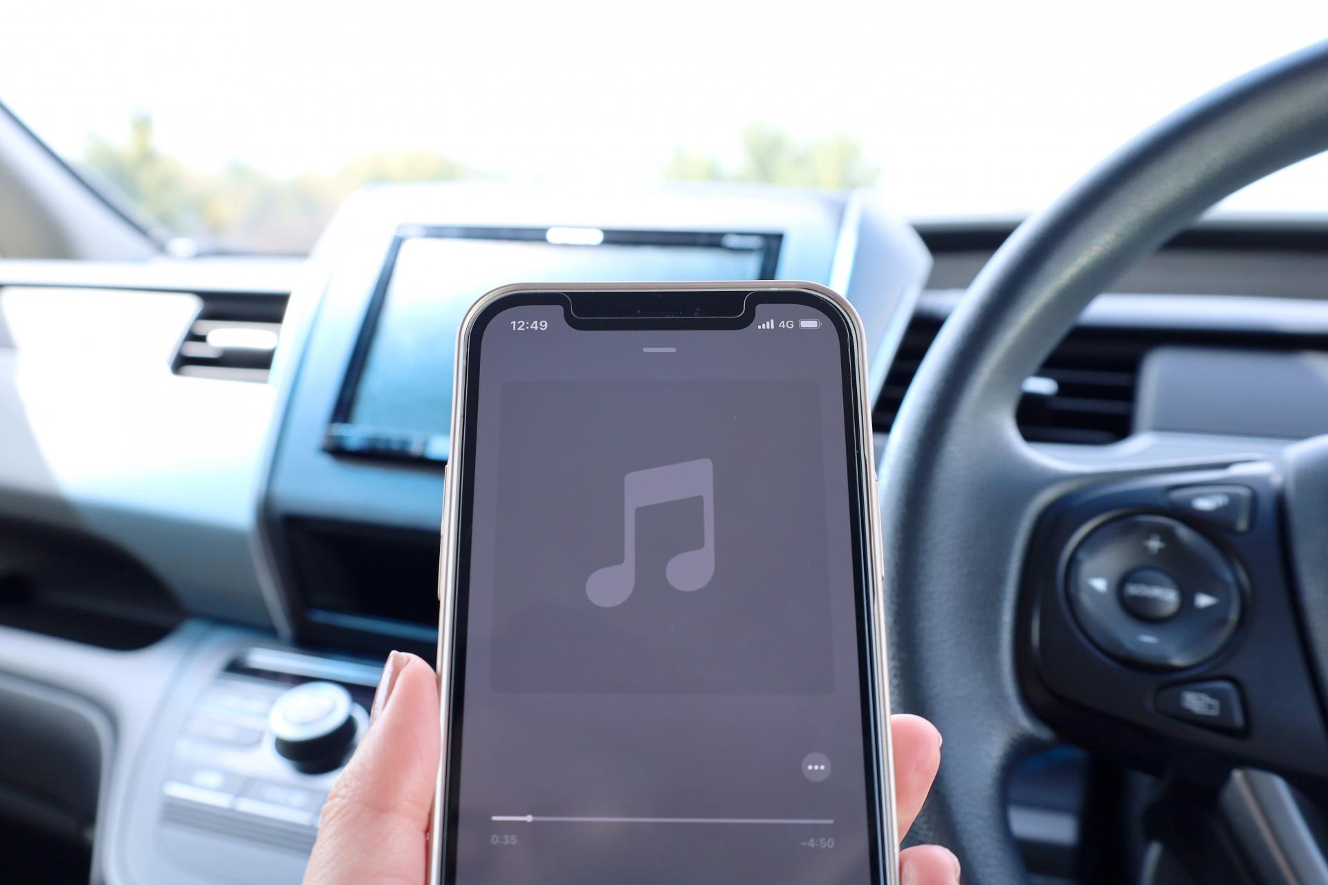 車内で音楽画面を表示したスマートフォン