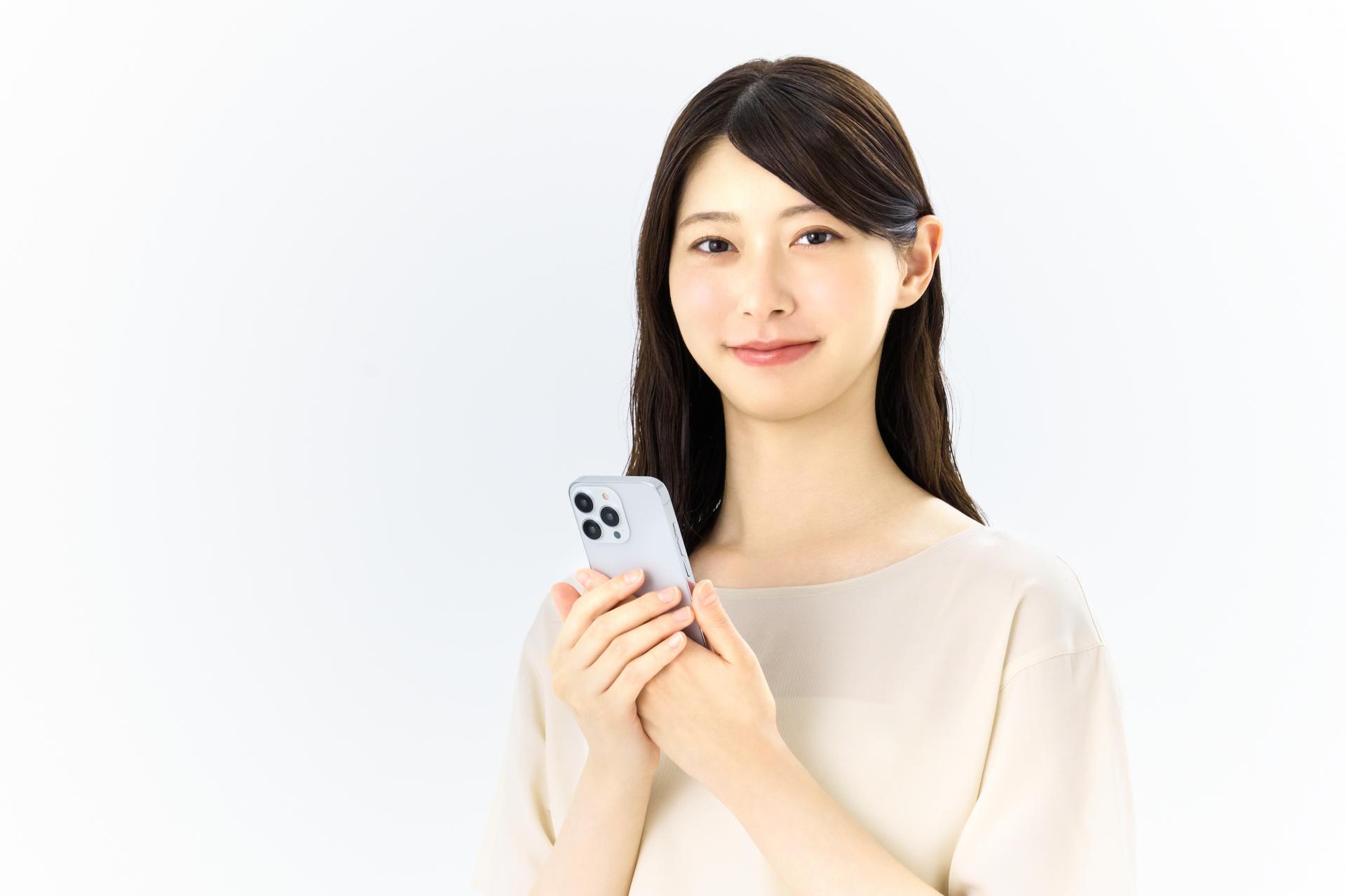 スマートフォンを持って微笑む女性