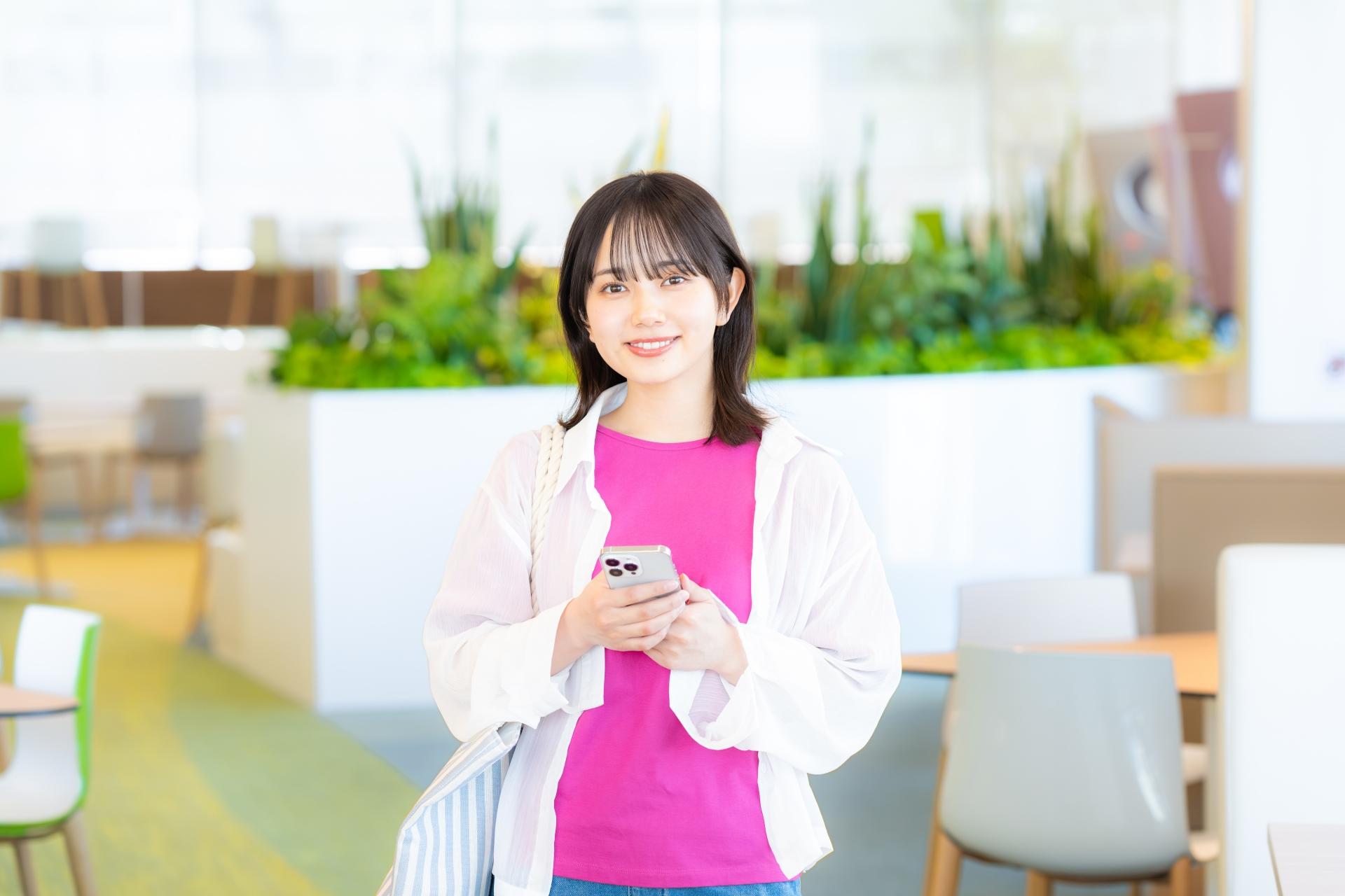 スマートフォンを持つジャケット姿の女性