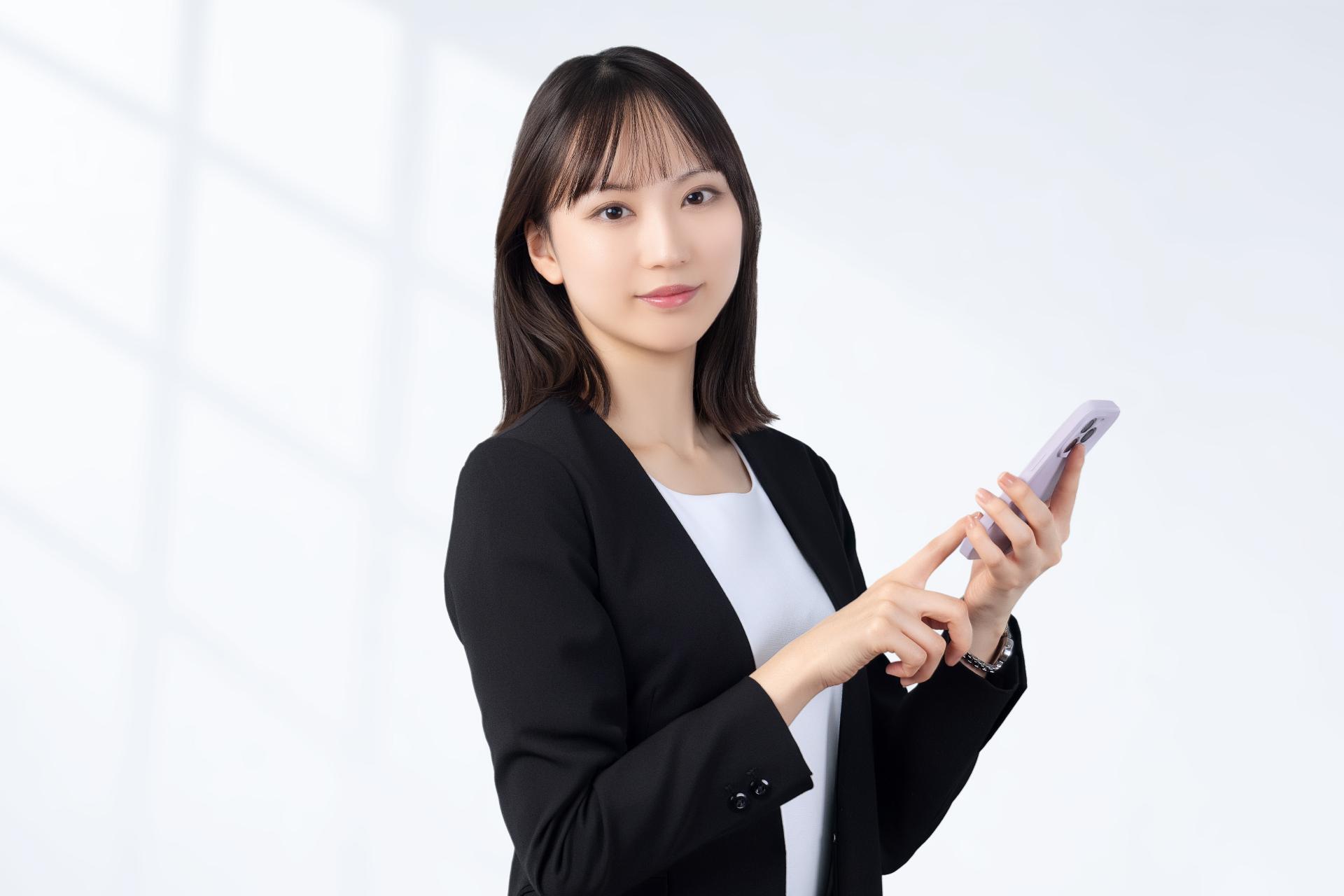 スマートフォンを操作するスーツ姿の女性